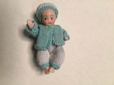 Porcelain  boy in outdoor knitted outfit